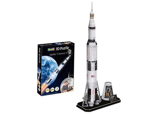 A 3D puzzle model of the Apollo 11 Saturn V rocket displayed next to its retail box on a plain white background. The puzzle is completed and stands on a black base next to a small landing module piece, with the packaging box showing the brand 'Revell' and the rocket against a blue Earth.