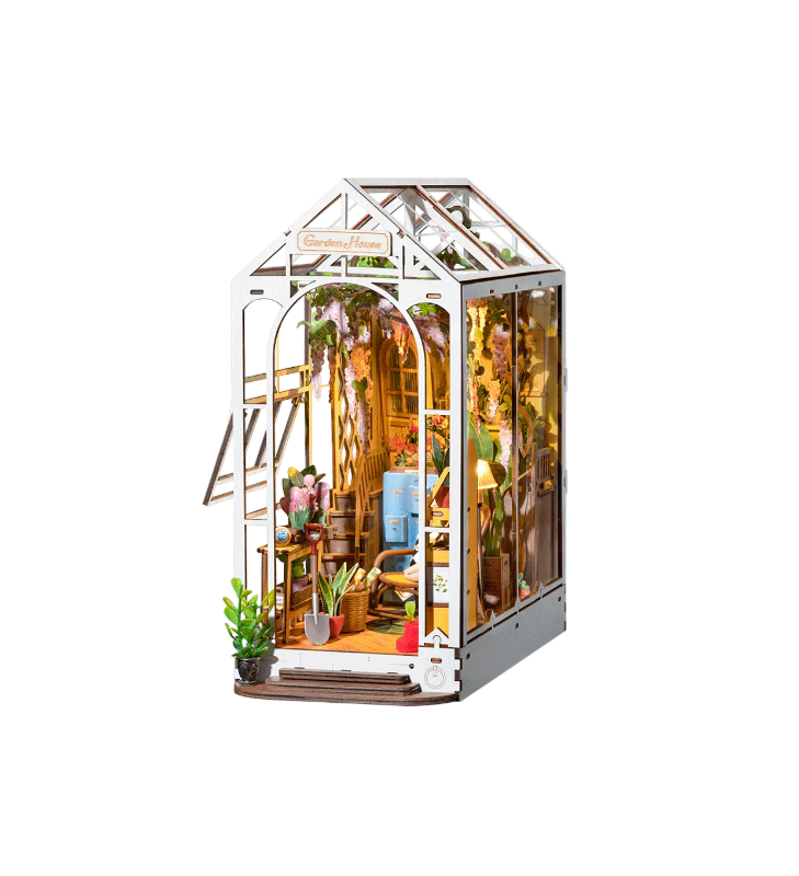 Model of a miniature greenhouse with plants and furniture on a white background